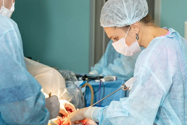 Una doctora usa una variedad de instrumentos médicos para realizar la cirugía. — Foto de Stock
