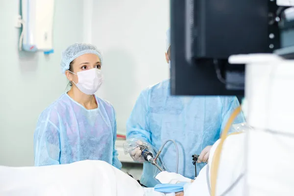 Una cirujana realiza una cirugía laparoscópica. — Foto de Stock