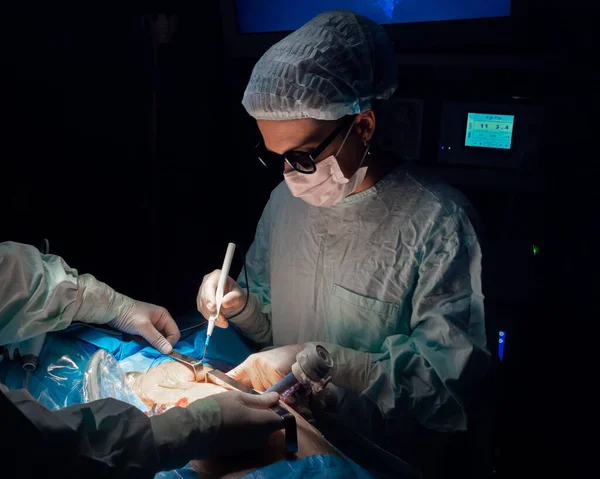 Una mujer cirujana en gafas 3D opera el cuerpo de los pacientes —  Fotos de Stock