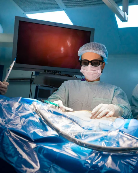 Cirurgiã com bisturi sobre o corpo das pacientes na sala de cirurgia — Fotografia de Stock