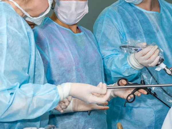 Instrumentos médicos en manos de un cirujano durante una operación quirúrgica. — Foto de Stock