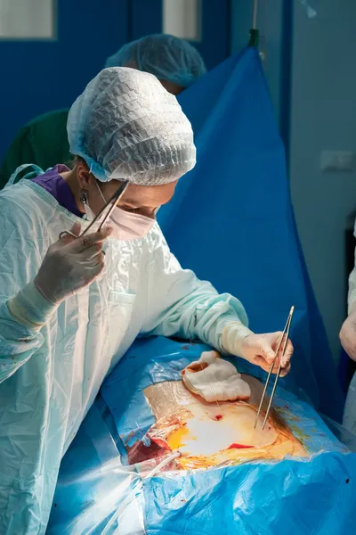 Female surgeon sutures the patients skin