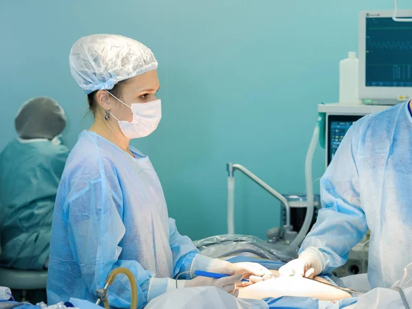 Eine Chirurgin führt eine Operation durch. lizenzfreie Stockfotos