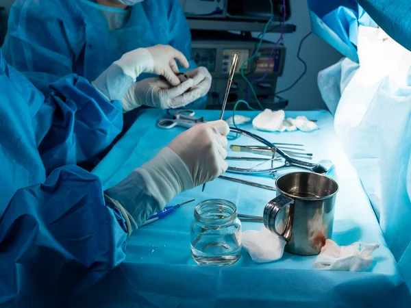 Un grupo de cirujanos que realizan una cirugía mínimamente invasiva en el ano de los pacientes utilizando instrumentos quirúrgicos . — Foto de Stock