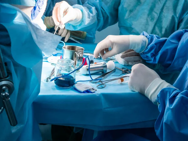 A group of surgeons performing minimally invasive surgery on the patients anus using surgical instruments. Stockfoto