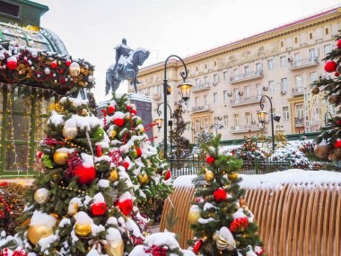 Moskova 'da karlı bir havada meydanda Noel ağacı. Şölen dekorasyonu ve arka planda atlar olan Noel atlıkarıncaları.. 