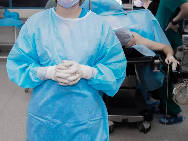 Ameliyathanede üniformalı bir cerrah ve lateks eldiven. — Stok fotoğraf