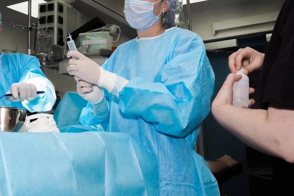 Um médico de uniforme cirúrgico prepara-se para injetar um paciente — Fotografia de Stock