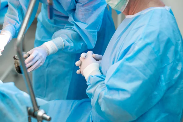 Chirurgen handen in witte latex handschoenen in de operatiekamer. — Stockfoto