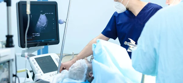 Doctors look at an ultrasound monitor while operating on a person. — Stock Photo, Image