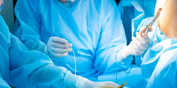 The surgeons hand in a sterile glove holds a fibrin glue dispenser. — Foto de Stock