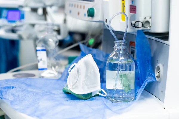 Beyaz tıbbi maske ve bir şişe salin.