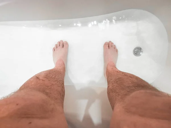 Волосатые мужские ноги в ванне с водой. — стоковое фото