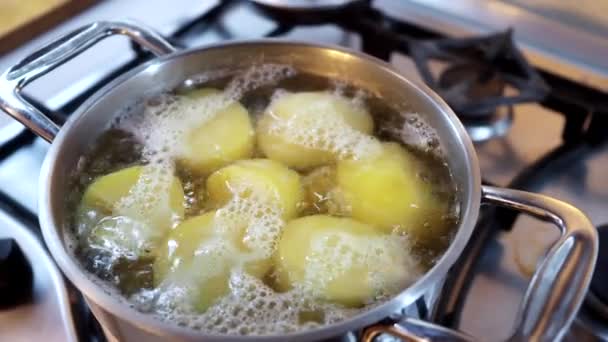 Крупный план картофельных клубней в кастрюле кипятят в кипящей воде. — стоковое видео