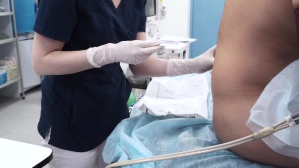 El anestesista inyecta una inyección epidural en la espalda de los pacientes. — Vídeos de Stock