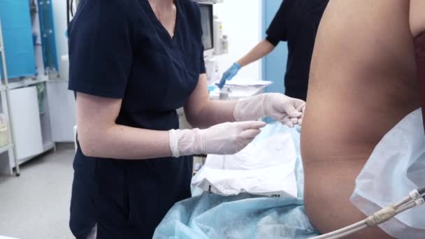 Doktor hastanın omuriliğine epidural anestezi için bir iğne yerleştirir.. — Stok video