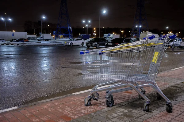 밤에 가게 옆에 있는 텅 빈 파란색 과 노란색 쇼핑 바구니. — 스톡 사진