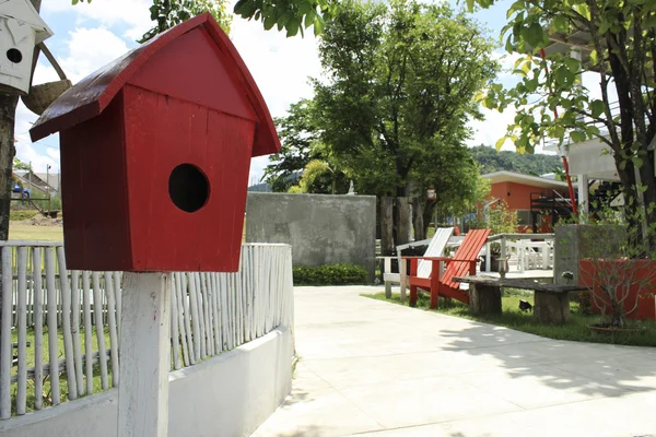 Red birdhouse w ogrodzie. — Zdjęcie stockowe