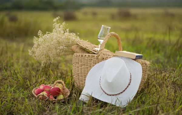 wicker white hat with wicker basket in a field in summer