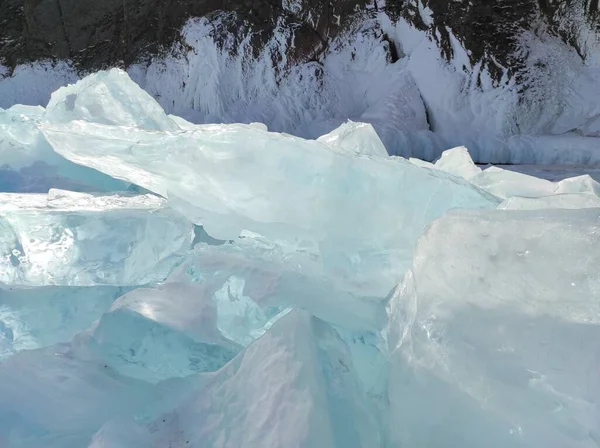Buzlu göl bir kayanın arka planında buz ve karla kaplıydı. — Stok fotoğraf