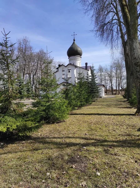 Vit kyrka på en bakgrund av blå himmel på våren — Stockfoto