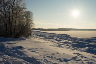 Donmuş bir gölde dondurucu, güneşli bir gün.