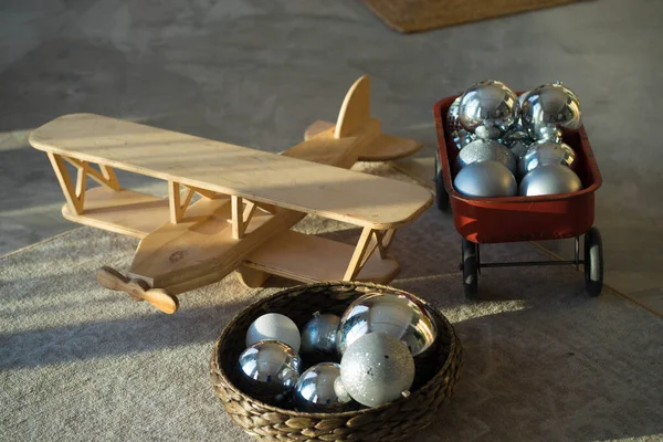 Pesawat kayu terletak di karpet dengan mainan pohon Natal yang besar — Stok Foto