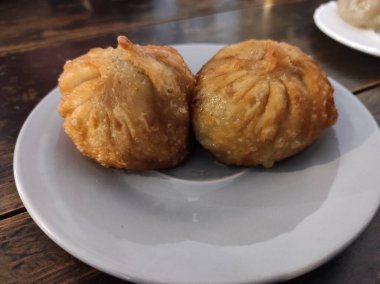 Büyük hamur köfteleri beyaz tabakta yatıyor.