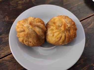 Büyük hamur köfteleri beyaz tabakta yatıyor.