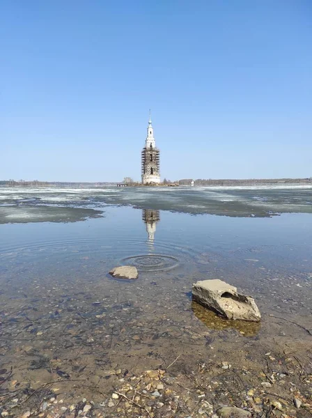 The ruined bell tower is reflected in the water in spring — Stock Photo, Image
