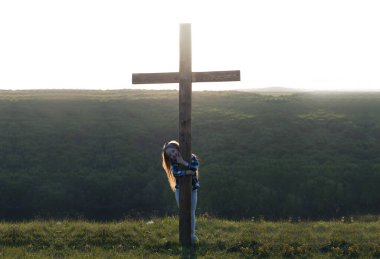 Geç. İsa 'nın tahta haçı. Çarmıha gerilme. Haçın yanındaki kız. Pişmanlık duası..