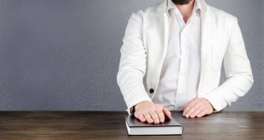 Yemin ederim. İncil üzerine yemin ederim. Ceketli bir adam İncil 'in üzerinde elini tutuyor. Söz ve Mutabakat.