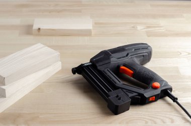 Elektrikli zımba. Demir kıskaçlar. Tahta blokları sık. İş eldivenleri. Atölyedeki alet. Çizgi ve kalem. Ahşap için marangoz robotlar. İş yerinde çalışan bir işçi.