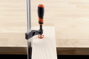 Kelepçe metal. İncelendi. Tahta bir masada. Vices ve clamps.