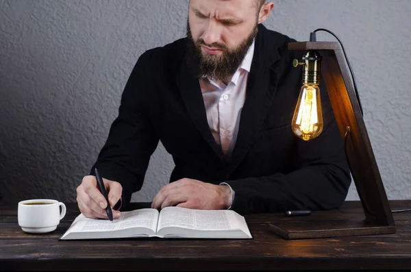 Man Writes Notebook Open Book Bible Man Sitting Table Book — Stock Photo, Image