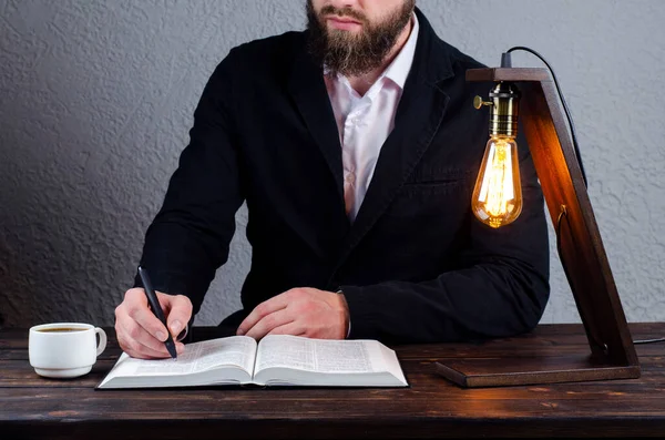 Man Writes Notebook Open Book Bible Man Sitting Table Book — Stock Photo, Image