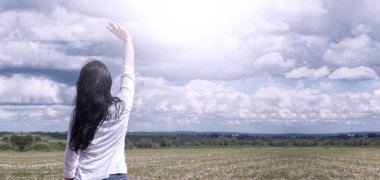 Dua et. Tanrı 'ya dua et. Elleri havada bir kız. İbadet. Gökyüzünün arka planına karşı. İstek.