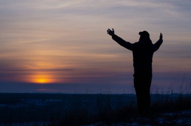 Prayer. Repentance. A man with his hands raised against the sky. Pray to God. Worship