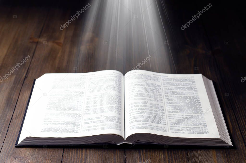 Bible. Open book. Light from a book. Old antique book. Magic, fairy tale.