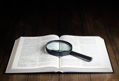 Açık İncil. Masanın üzerinde. Kutsal İncil, Kutsal Kitap. Büyüteç
