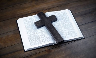 İncil açık. Haç, İsa 'nın çarmıha gerilmesi. Aşk konsepti. Tahta bir masada..