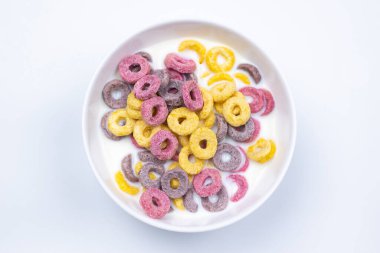 Mısır gevreği, beyaz tabakta. Kahvaltıda. Beyaz bir arka planda. Süt.