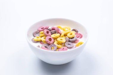 Mısır gevreği, beyaz tabakta. Kahvaltıda. Beyaz bir arka planda. Süt.