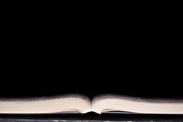 Open Bible. On a black background. Holy book.