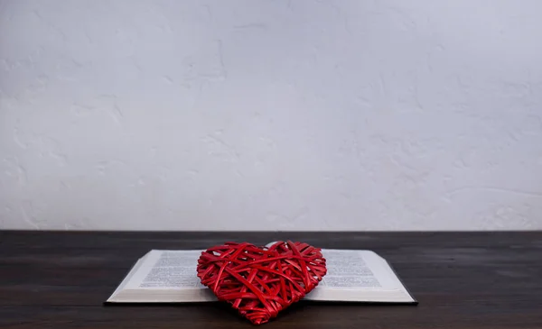 Open Holy Bible, on the table. Prayer. Heart on the book. Love of God