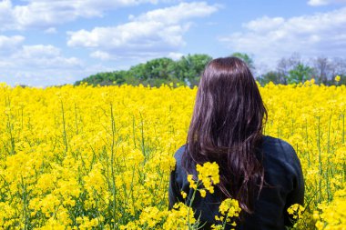 Sahadaki genç kız. Tarlada kolza bulaşmış bir kadın. Bahar Yazı