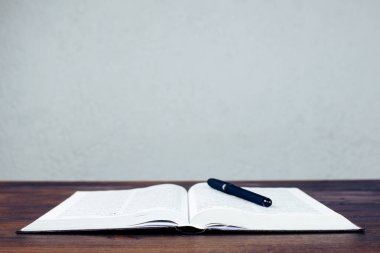 Open Bible. Book and pen on the table. Prayer.