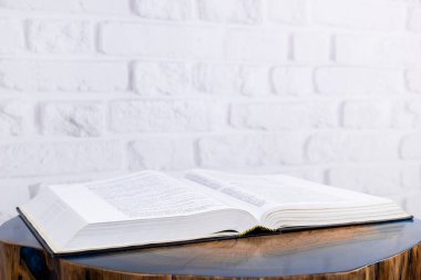 Kitap masanın üzerindedir. Kutsal İncil 'i aç. Dekoratif ahşap masa.