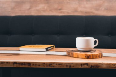 Bir fincan kahve ve masanın üstünde bir kitap..