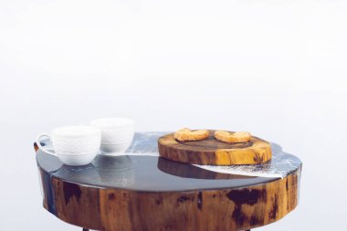 Masanın üzerinde bir fincan kahve. Beyaz zemin üzerinde ahşap masa.